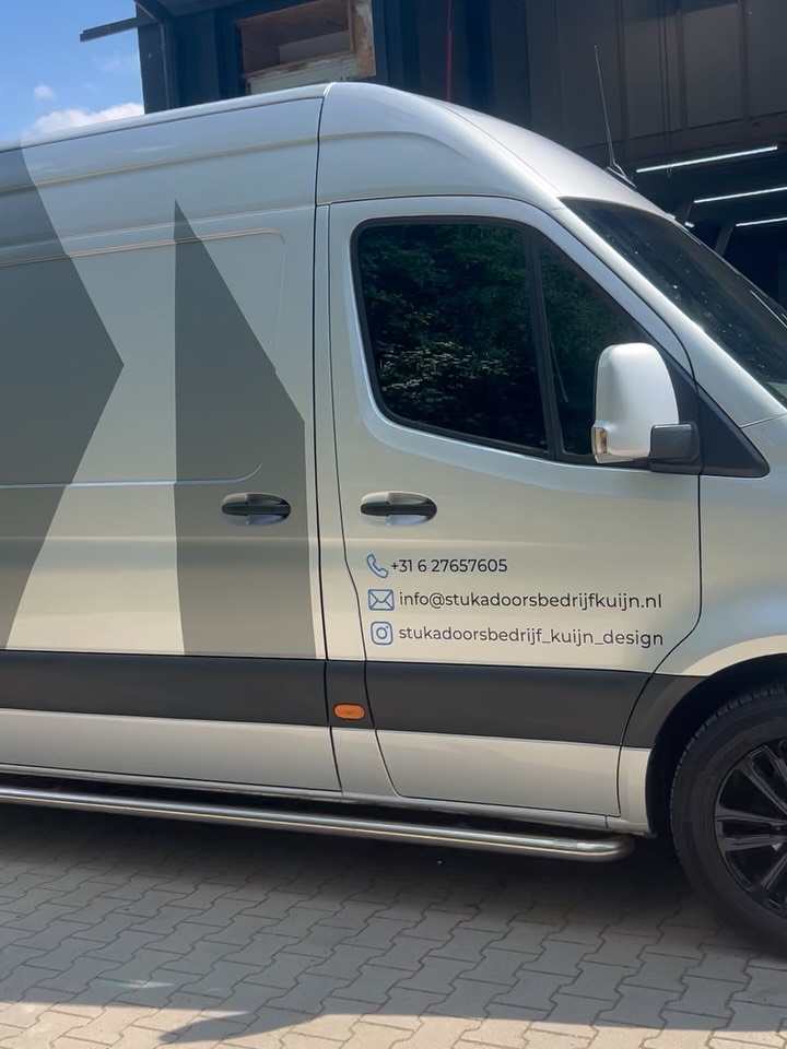 De bus van Stukadoorsbedrijf Kuijn met telefoonnummer en e-mailadres op de deur